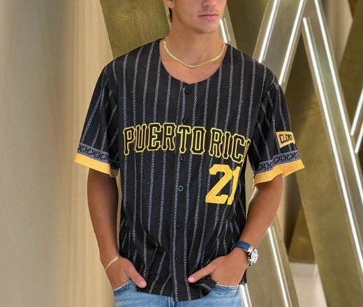Jersey negro con nombres de pueblos de Puerto Rico y gorra a juego. 