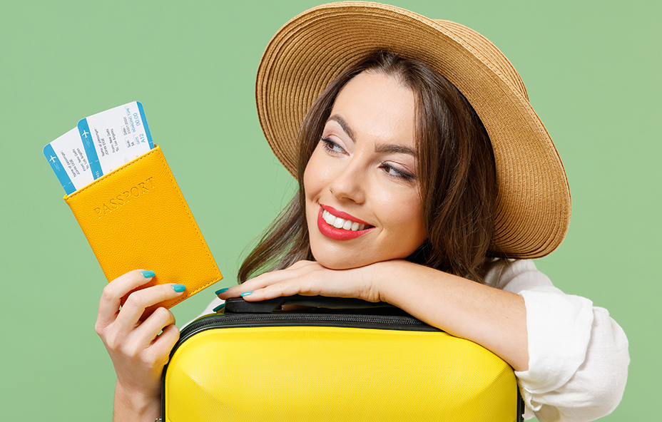 Mujer con sombrero, maleta y boletos de viaje