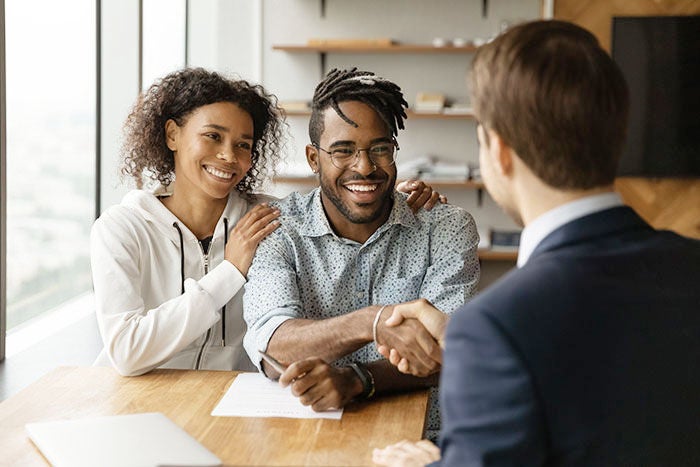 African couple shake hand financial advisor after sign contract