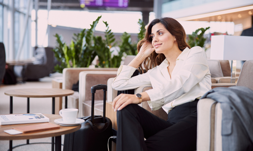 Thoughtful girl sitting on furniture next to suitcase.