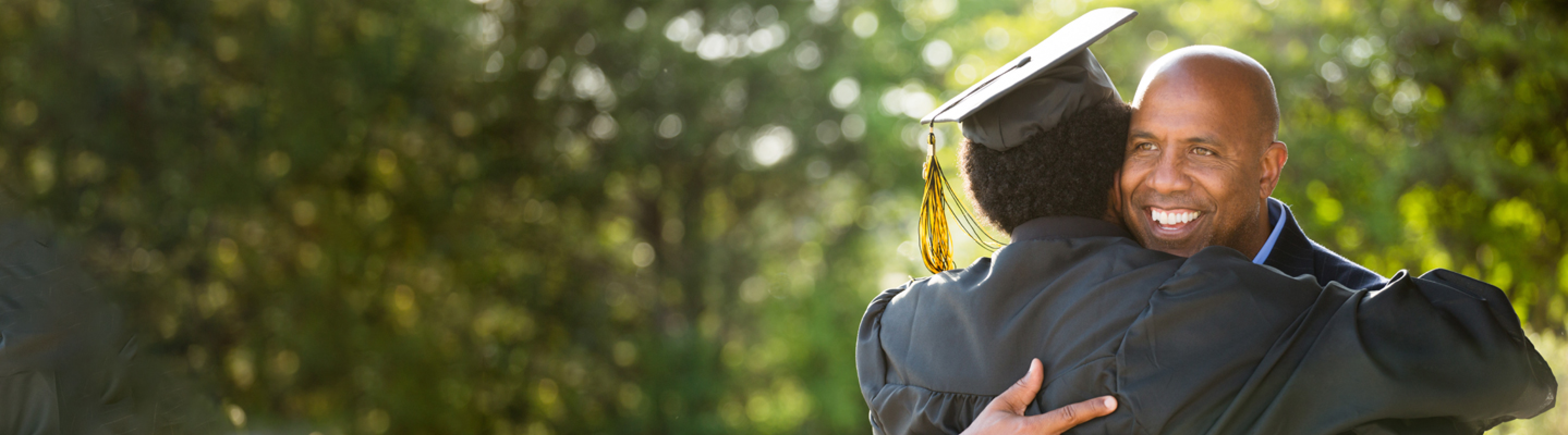 Father hugging his recently graduated son.