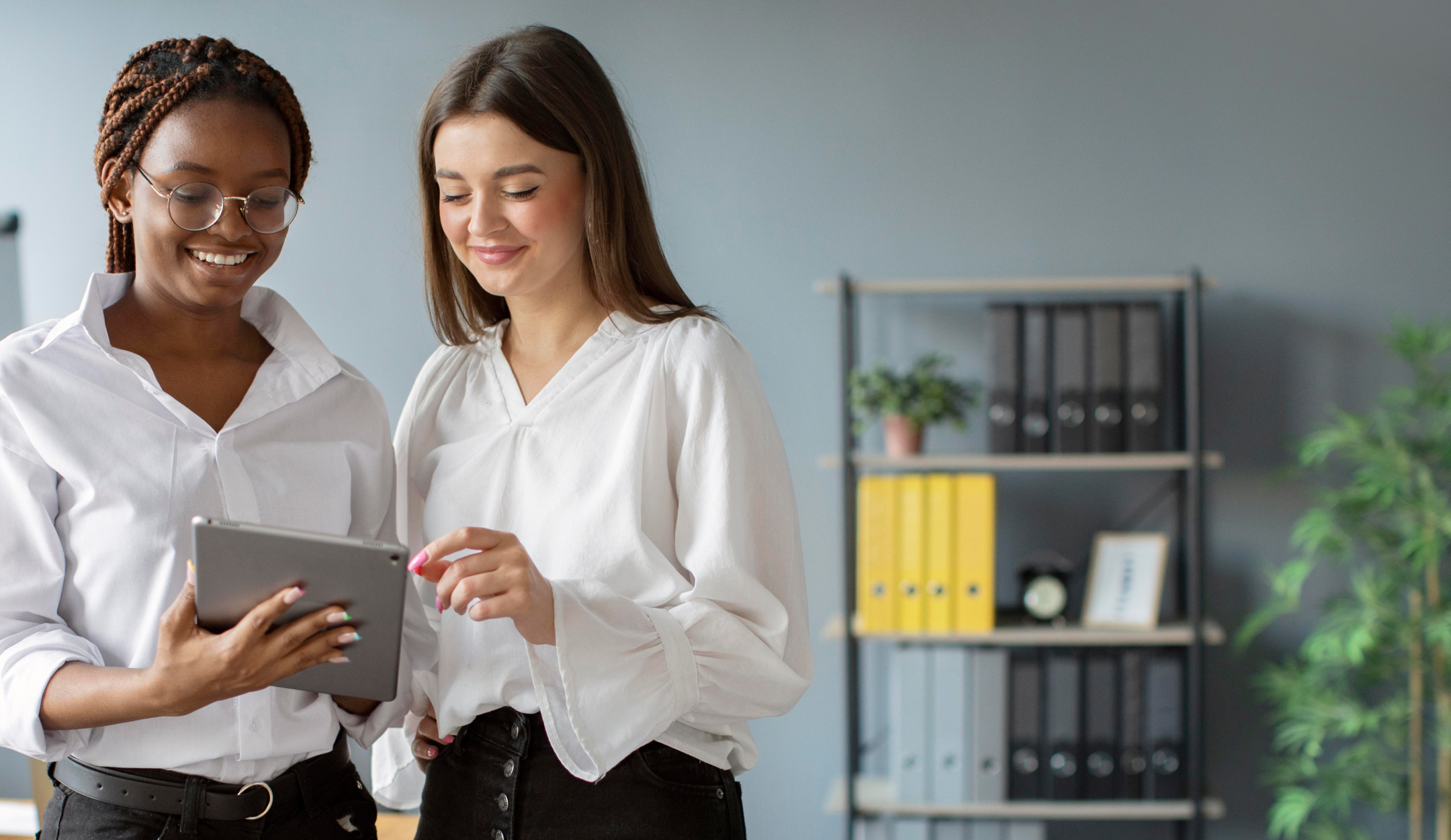 Two girls looking at the screen of a tablet