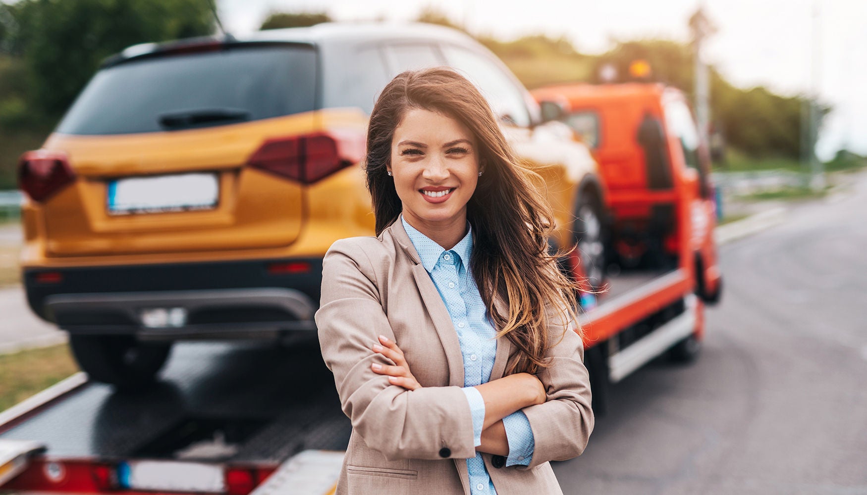 Young woman in front of a tow with a car