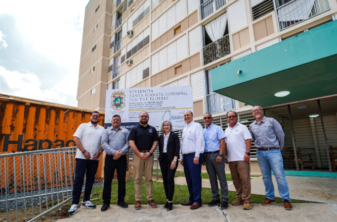 Personas sonriendo frente al proyecto de vivenda en bayamon