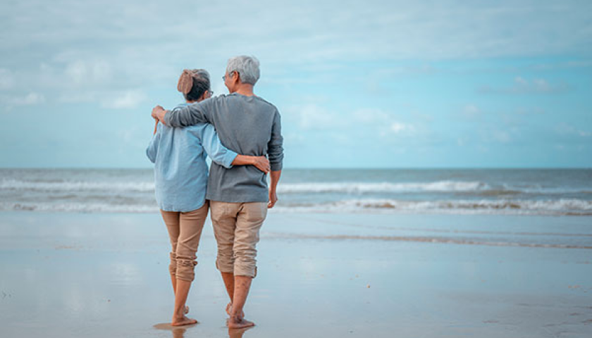 old couple walking at the beach