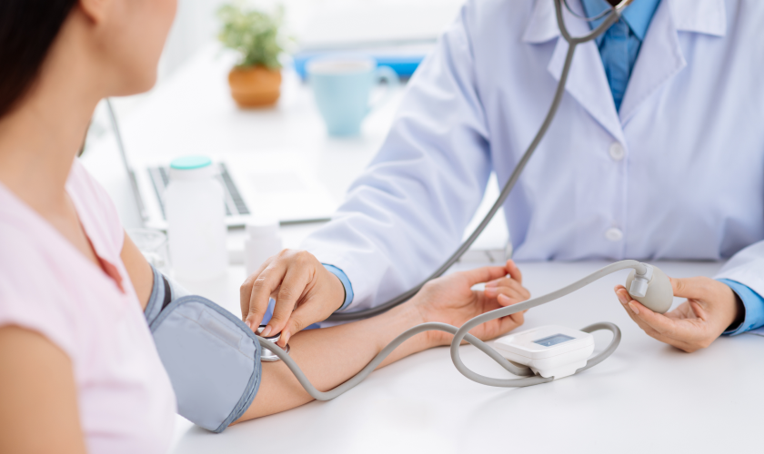 Doctor measuring pressure with instrument to girl.