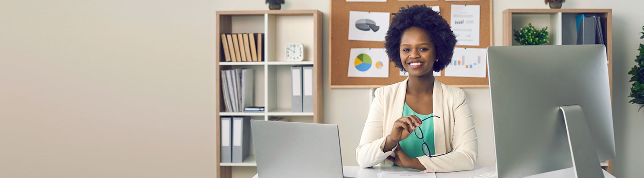 Woman sitting at desk with a computer screen.