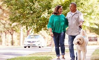 couple walking dog outside