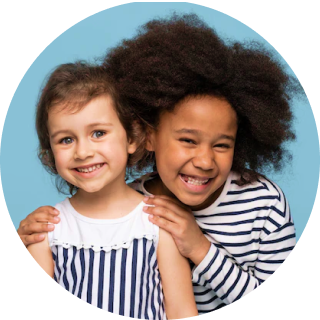 Two little girls hugging and smiling