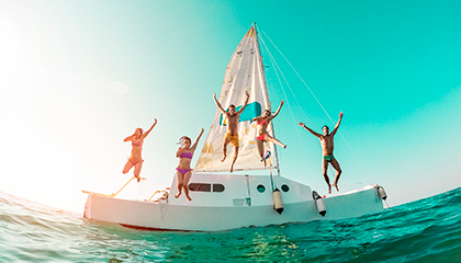 Five friends jumping into the sea from a boat