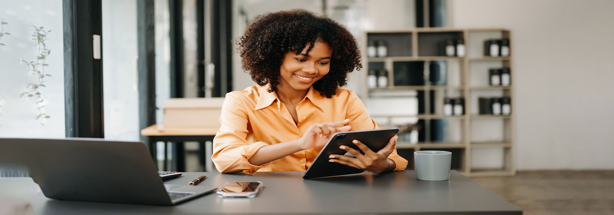 woman smiling and looking a tablet