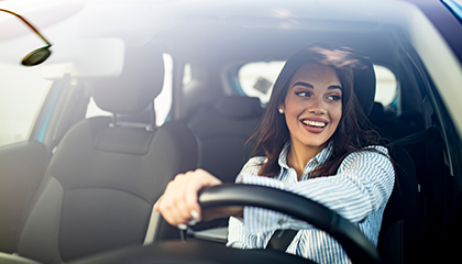 Chica joven conduciendo un carro mientras sonríe