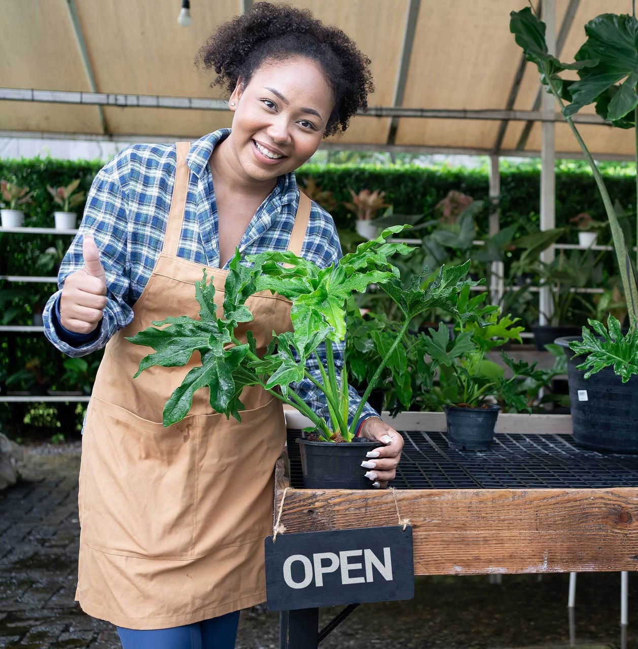 Woman smiling with plant in hand.