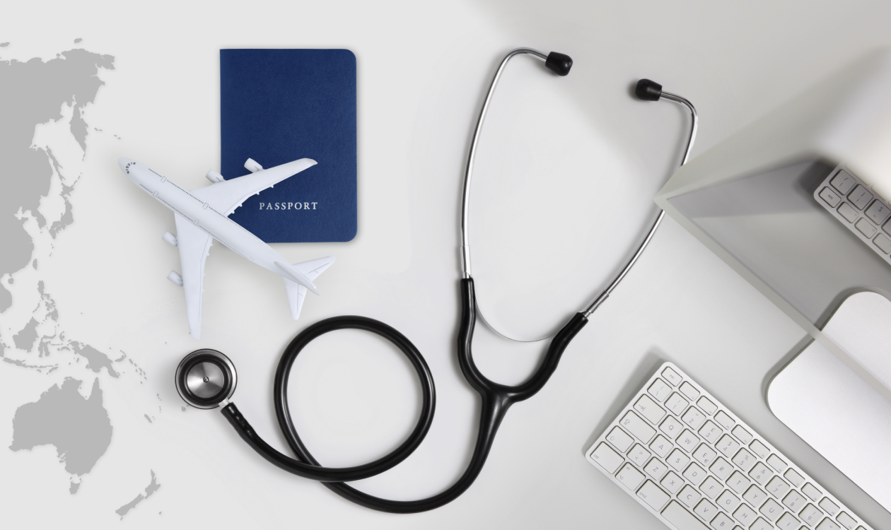 Stethoscope next to passport and toy plane.