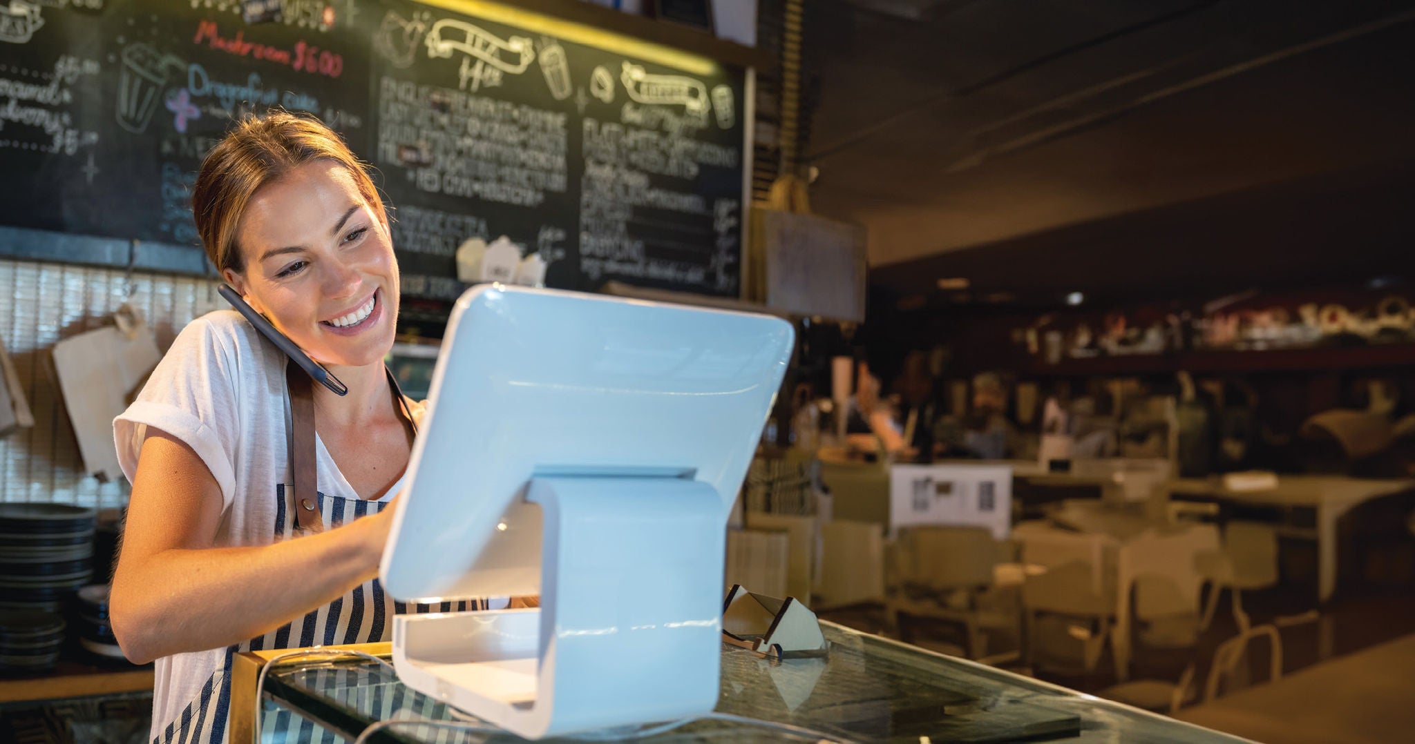 Mujer frente caja registradora en cafe