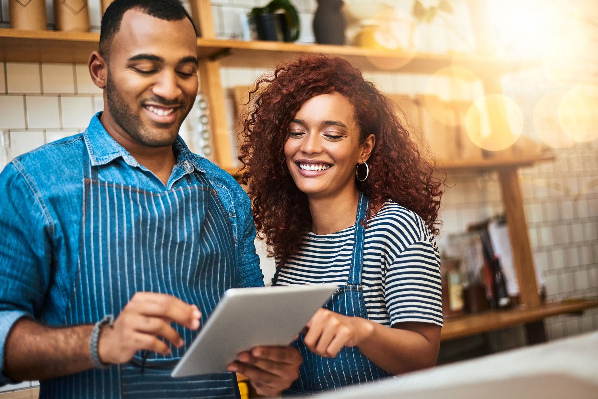 business couple smiling and looking at a tablet