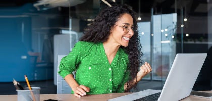 mujer sonriendo fente a computadora 