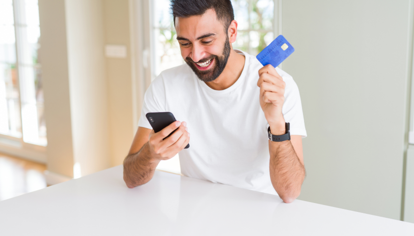 Joven sosteniendo una tarjeta y su celular