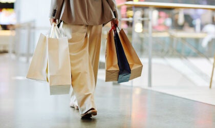 Woman holding bags while walking in mall.