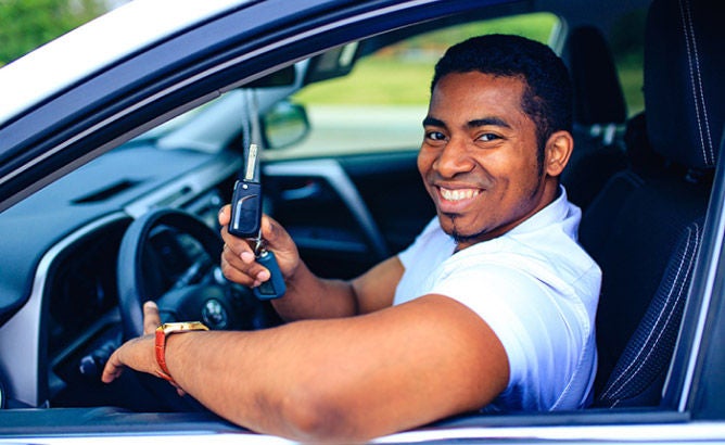 Man in a hat hugs his car