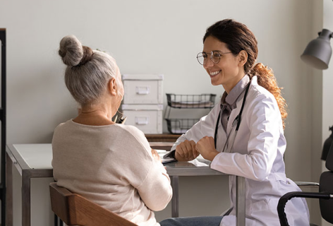 Female doctor smiling at a old lady