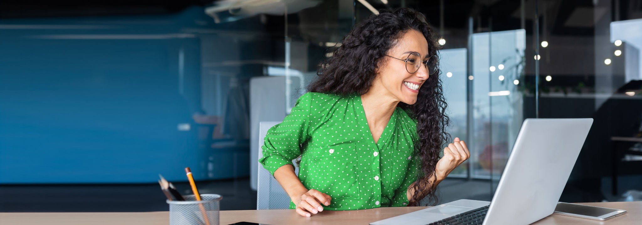 mujer sonriendo frente a una computadora movil