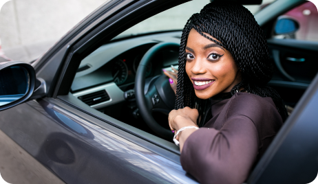 Woman smiling inside her car.