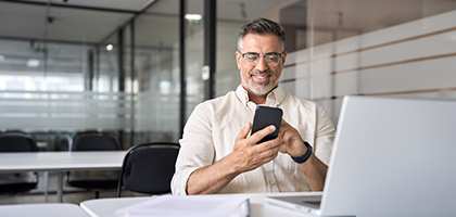 hombre sonriendo con telefono en mano