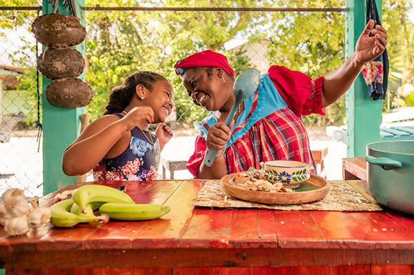 Mother and daughter smiling while cooking.