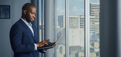 man wearing suit holding laptop while watch it