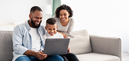 family with laptop in a sofa