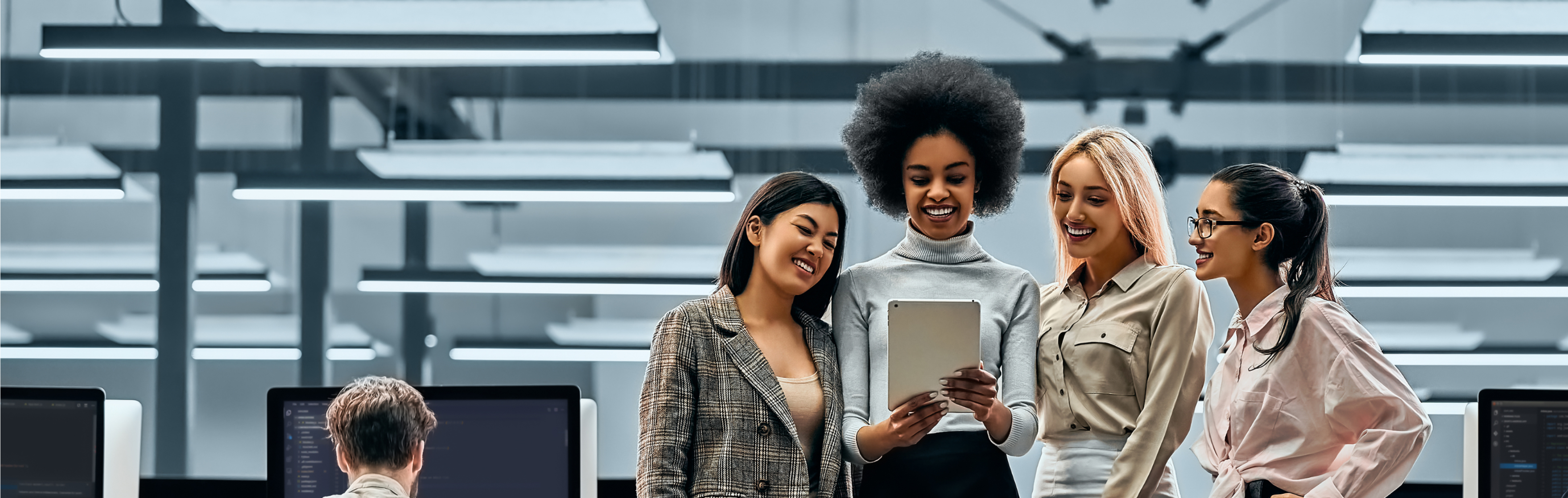 4 women talking, smiling and looking at tablet