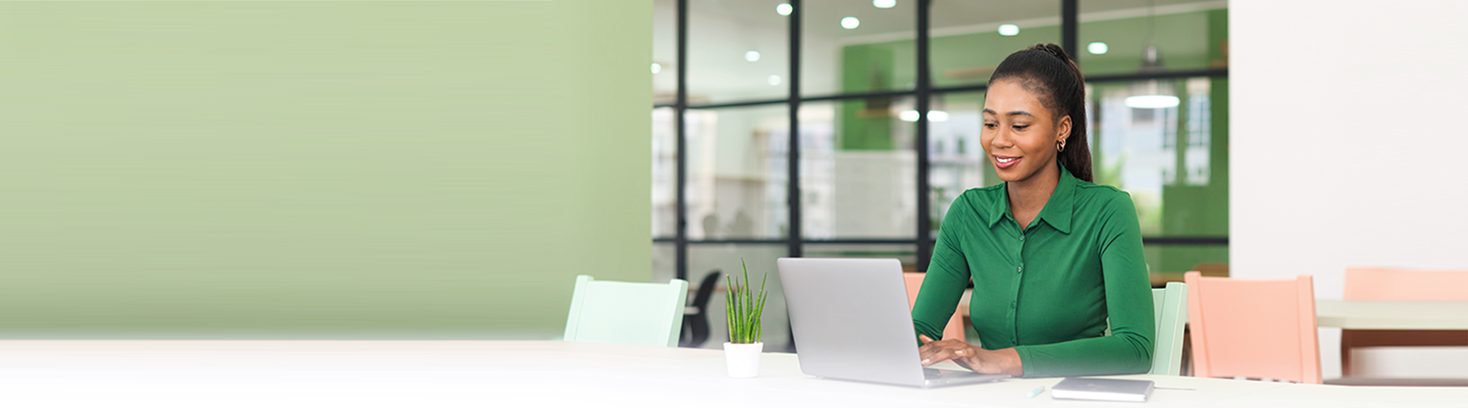 lady in green blouse sitting in front of laptop