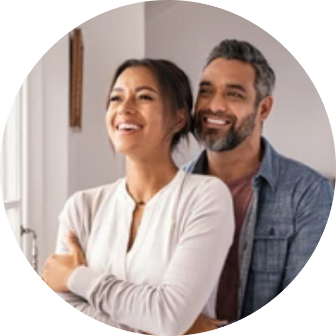 Couple smiling while watching straight ahead.