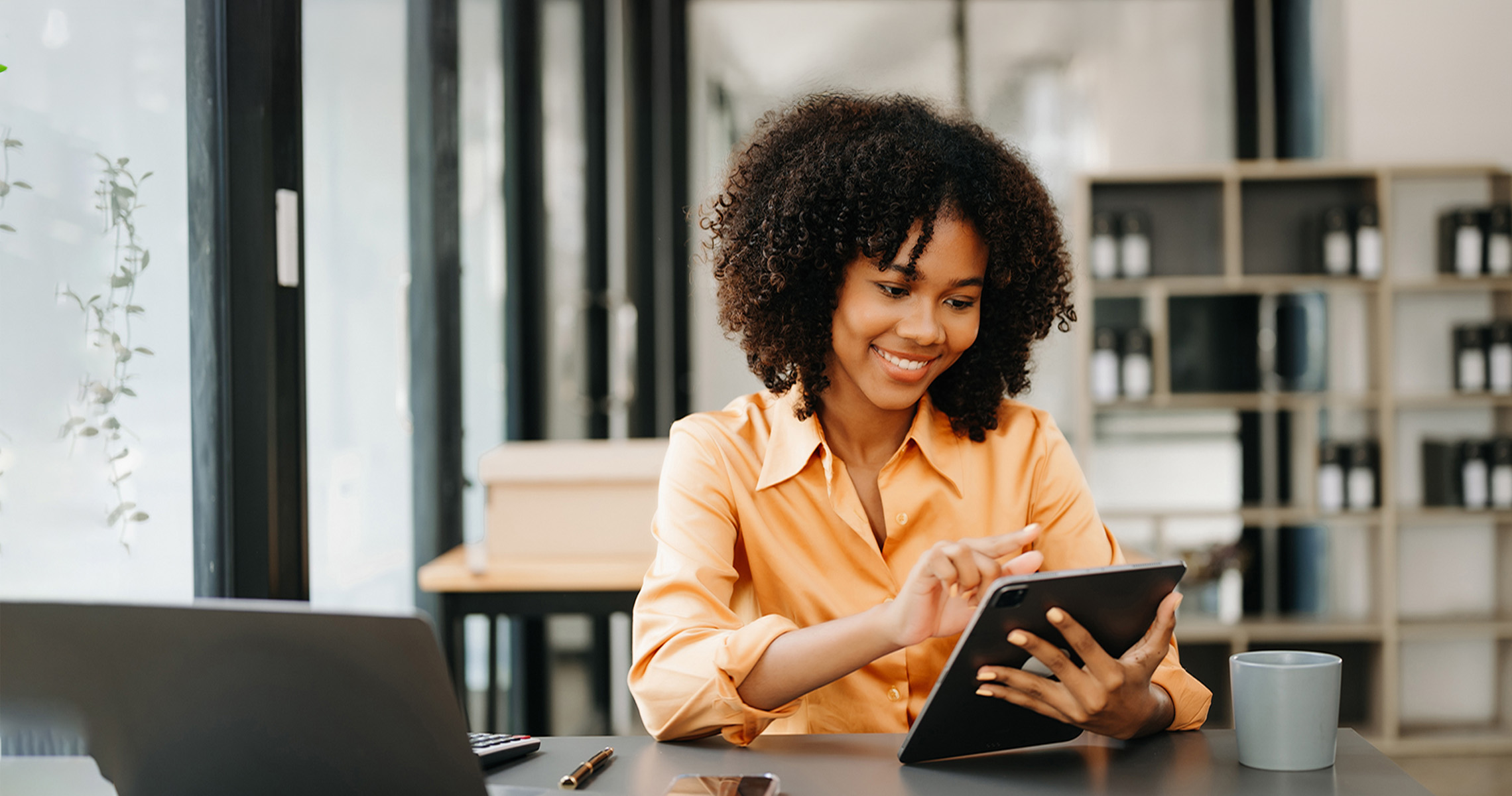 Mujer de negocios usando la tableta y el ordenador portátil para hacer finanzas matemáticas en un escritorio de oficina.