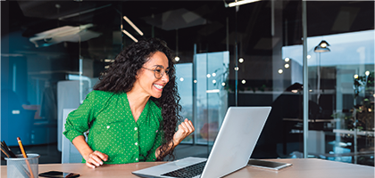 Mujer sonriendo frente a una computadora